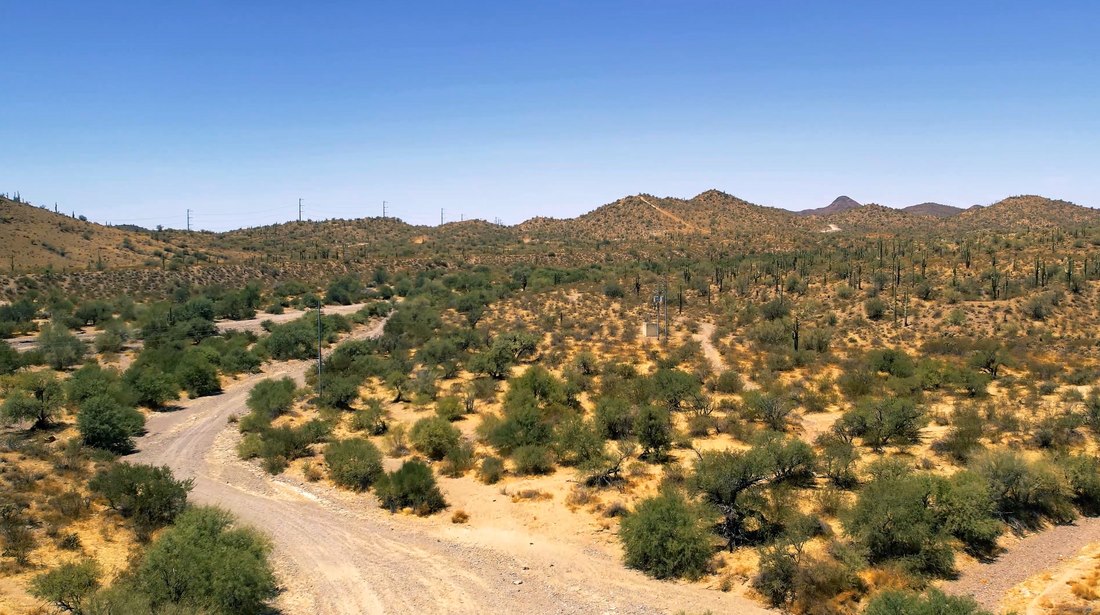 Aerial view across foothills and a dirt route